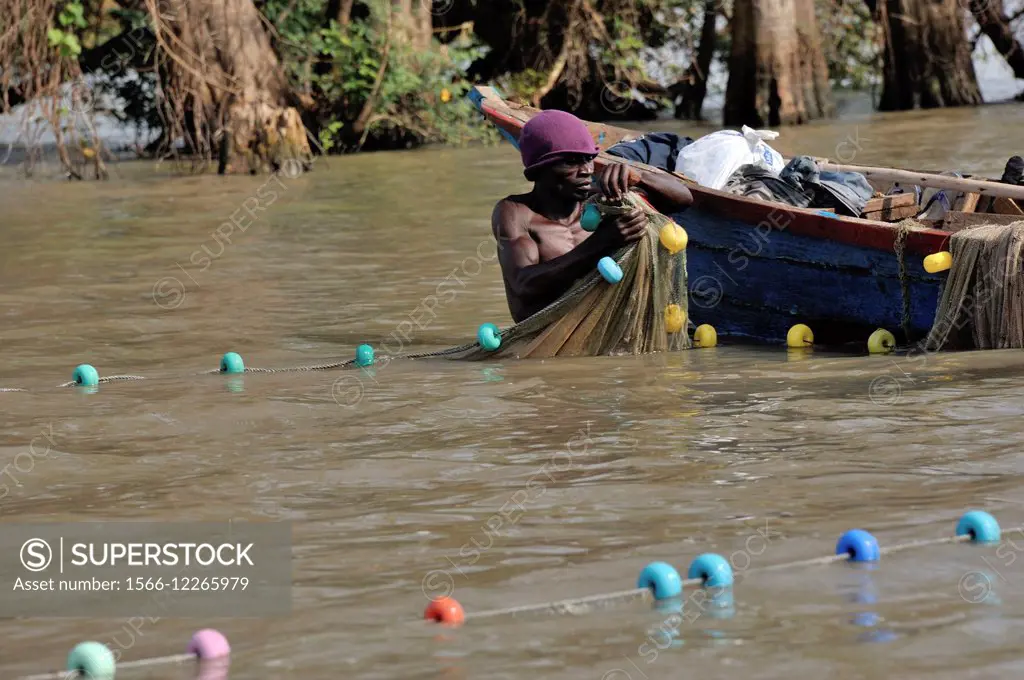 Fisher at work, man hauling big fishing net, Lake Victoria, Kenya