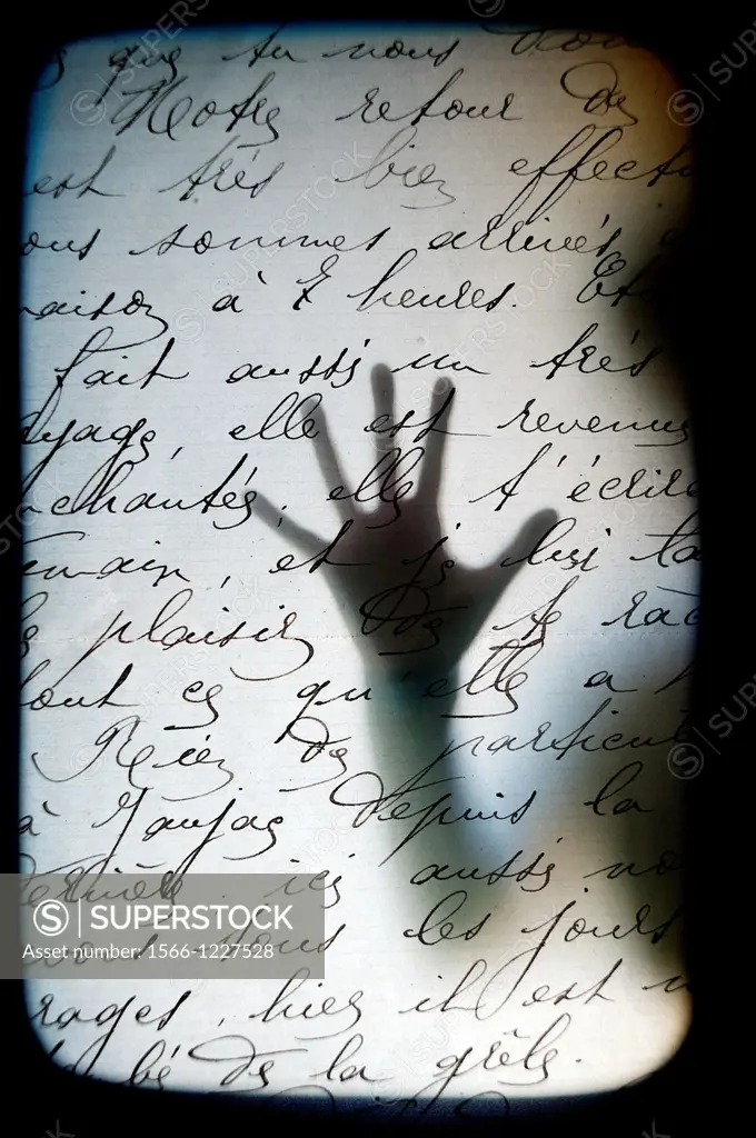 Silhouetted hand on handwritten text