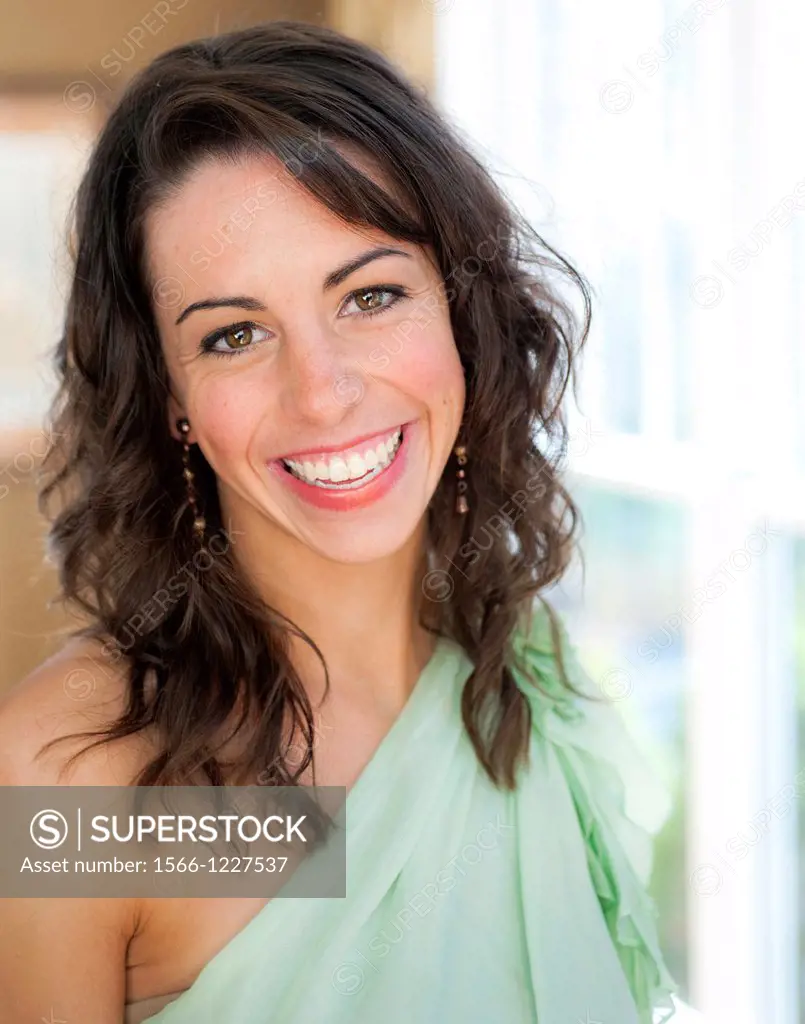 Casual portrait of a 22 year old brunette woman smiling at the camera