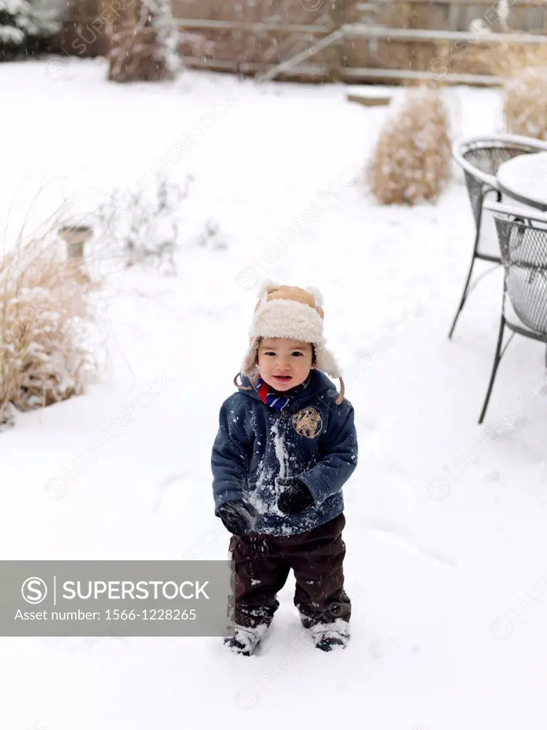 A young mixed ethnicity child playing in the snow