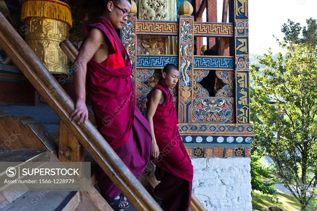 Two buddhist monks going down the stairs of Punakha Dzong, Punakha, Bhutan, Asia.