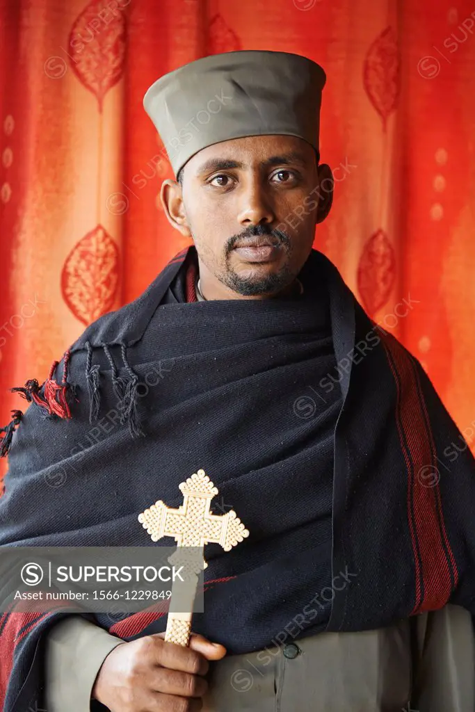 A portrait of an Ethiopian priest holding a coptic cross