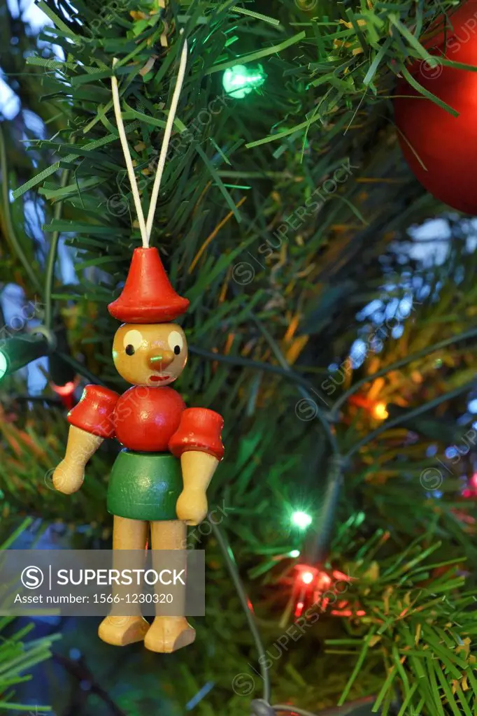 In addition to glass ball and lights, many people put handmade ornaments on their Christmas tree  Red and green wooden Pinocchio