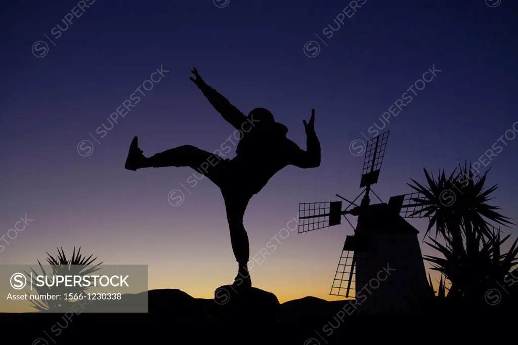 Young man exercising at dawn by a traditional old windmill in Fuerteventura, Spain