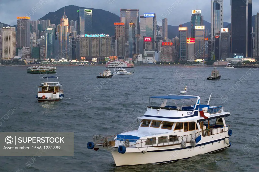 A private yacht moored in Victoria Harbor at sunset  In the background commercial high rise buildings in Admirality and Wanchai on hong kong island  h...
