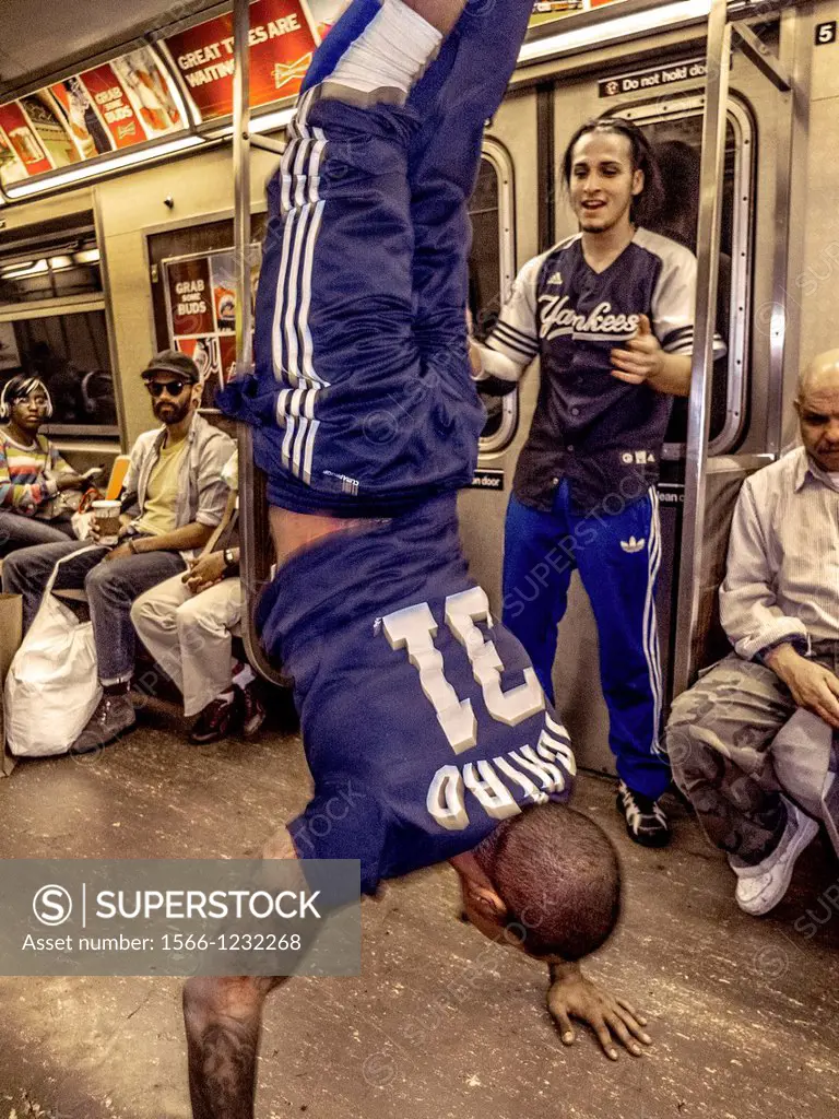 An African American man dances for passengers tips while riding in the New York City subway  Note partner