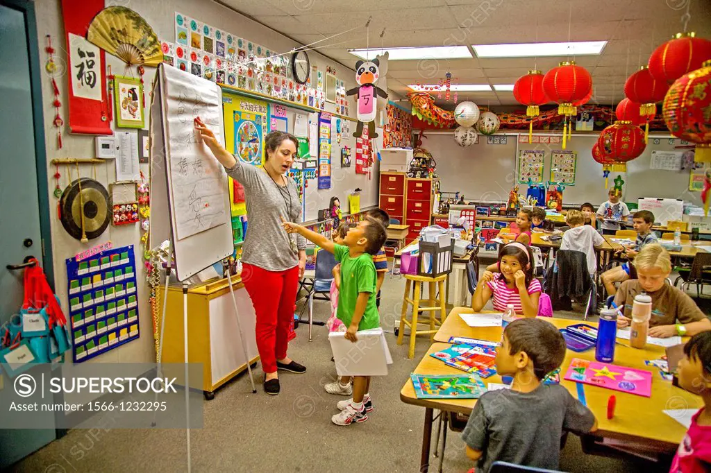 First-grade students learn Mandarin Chinese in a Laguna Niguel, CA, elementary school  Note Chinese characters on A-frame chart  The teacher speaks in...