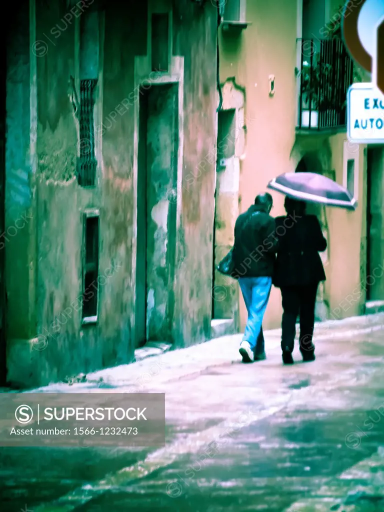 Couple under an umbrella, street. Tarragona, Catalonia, Spain.