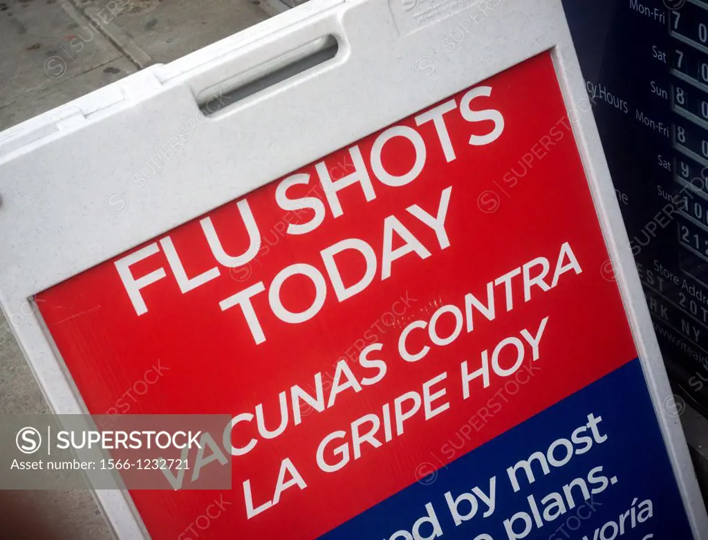 A sign in English and Spanish advertises that flu shots are available at a drugstore in New York