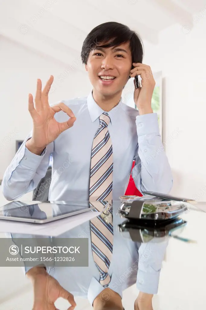 Young Asian businessman talking on his smartphone