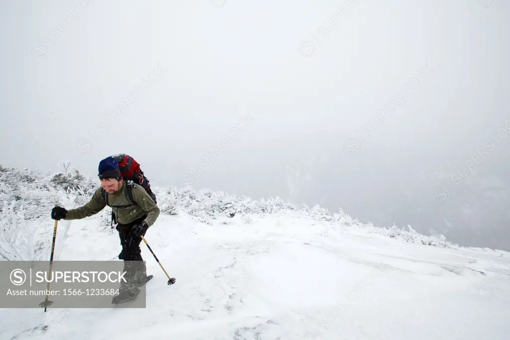 Franconia Notch State Park - Hiker at scenic view point along Kinsman Ridge Trail in whiteout conditions  This trail leads to the summit of Cannon Mou...