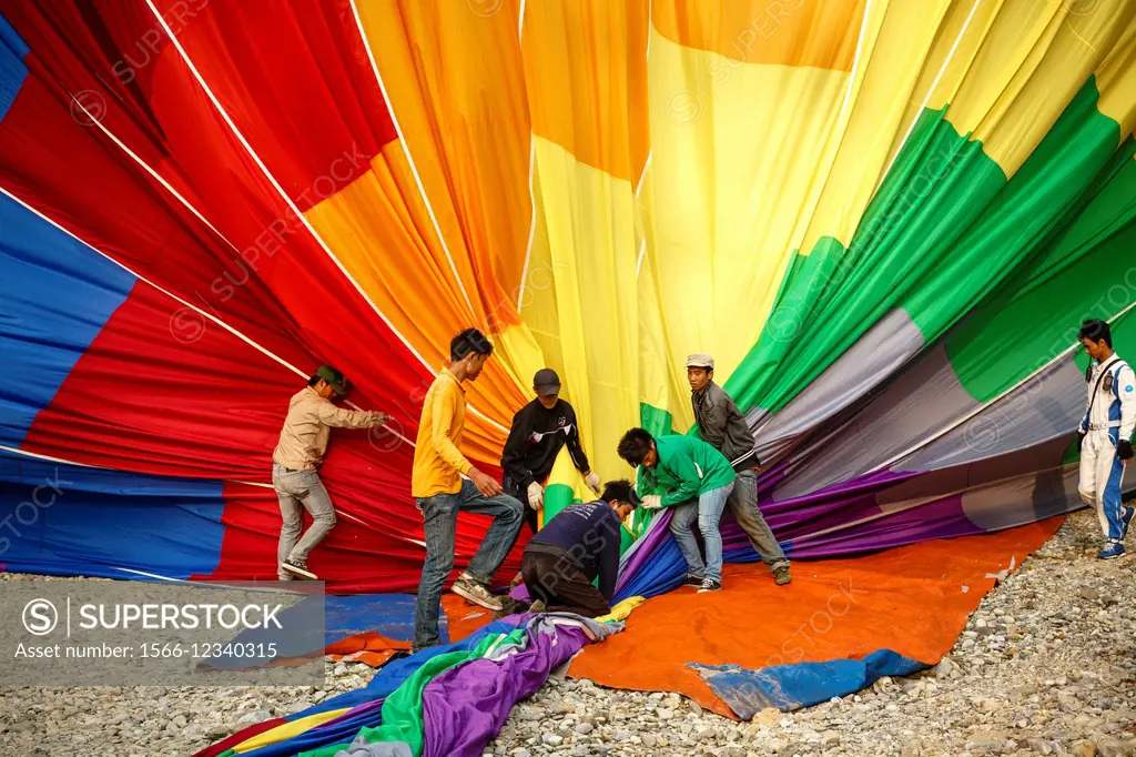 People folding a hot air balloon, Vang Vieng, Laos.