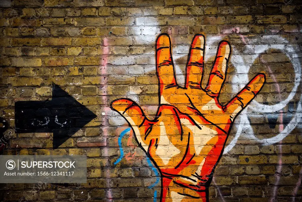 Graffitty of a hand and an arrow on a wall in East End London, England, UK, Europe.