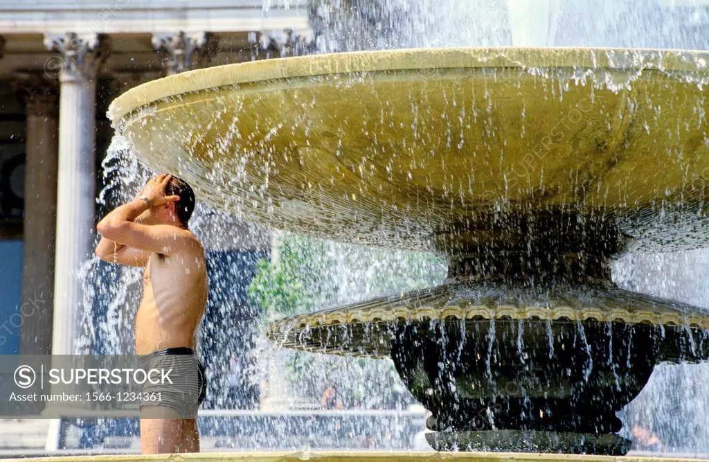 Man bathing in a basin, Trafalgar Square in summer, London, England, UK