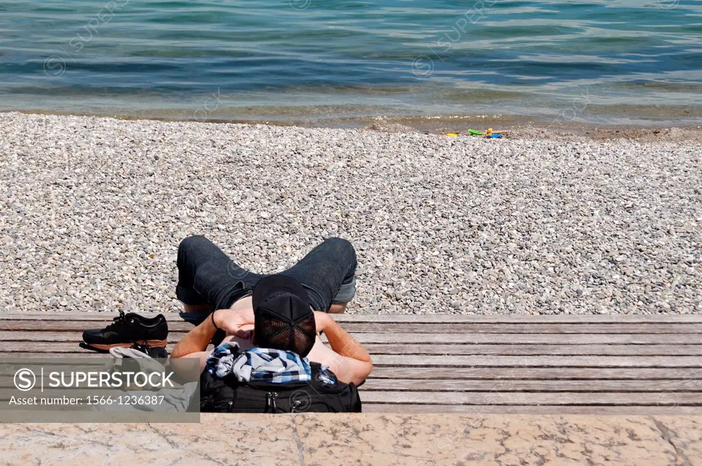 young man resting, laying in the sun, Paquis beach, May, Geneva, Switzerland