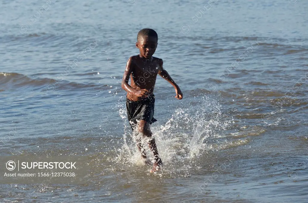 A young boy running in Livingston beach, Guatemala, Central America.