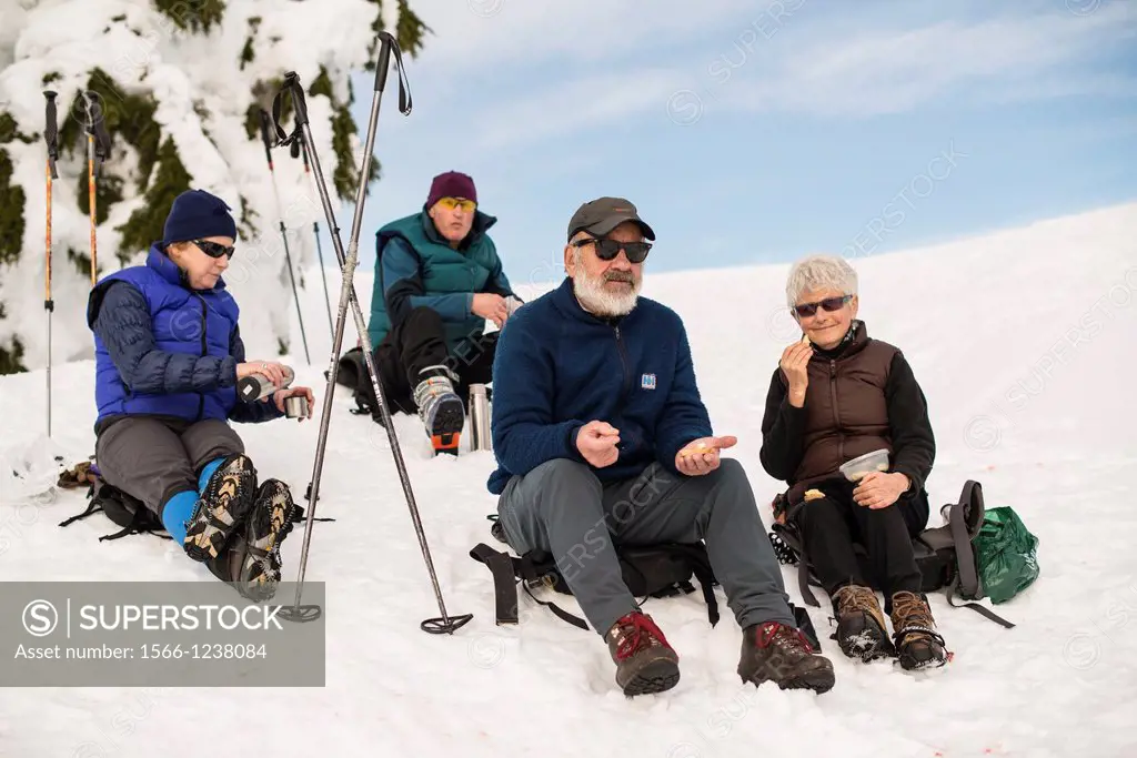 a group of hikers sit for lunch in winter on Mt Seymour, North Vancouver, BC, Canada
