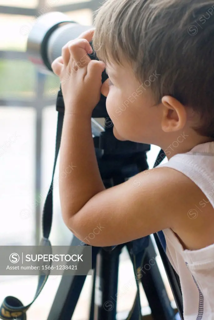Little boy taking pictures with a camera.