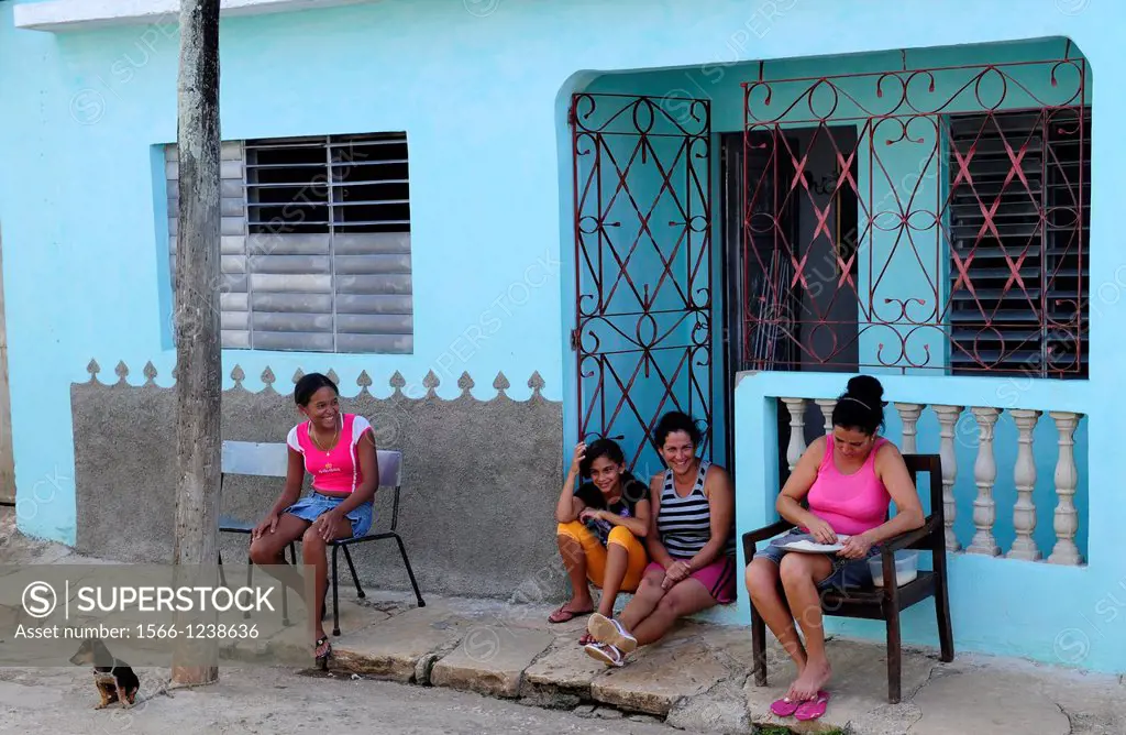 Women and young girl sitting in front of house in Remedios,Villa Clara Province,Cuba