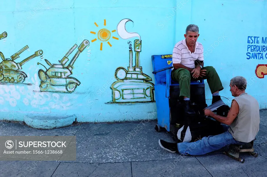Shoeshine man polishing his customer shoes in Santa Clara,Villa Clara Province,Cuba