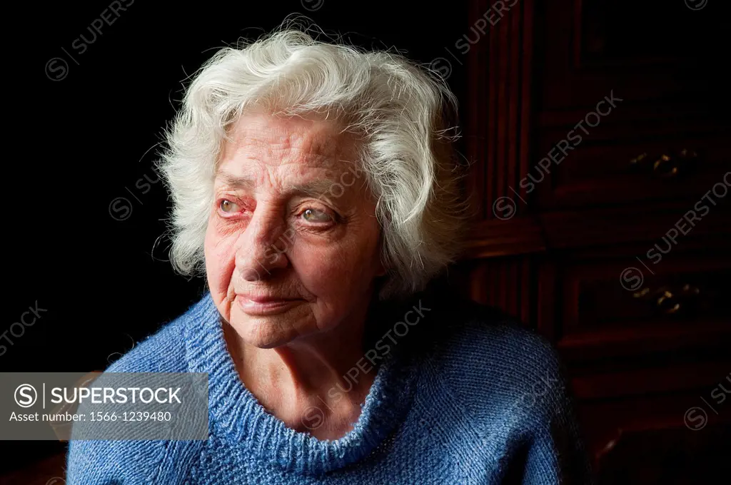 Portrait of old woman at home, looking up. Close view.