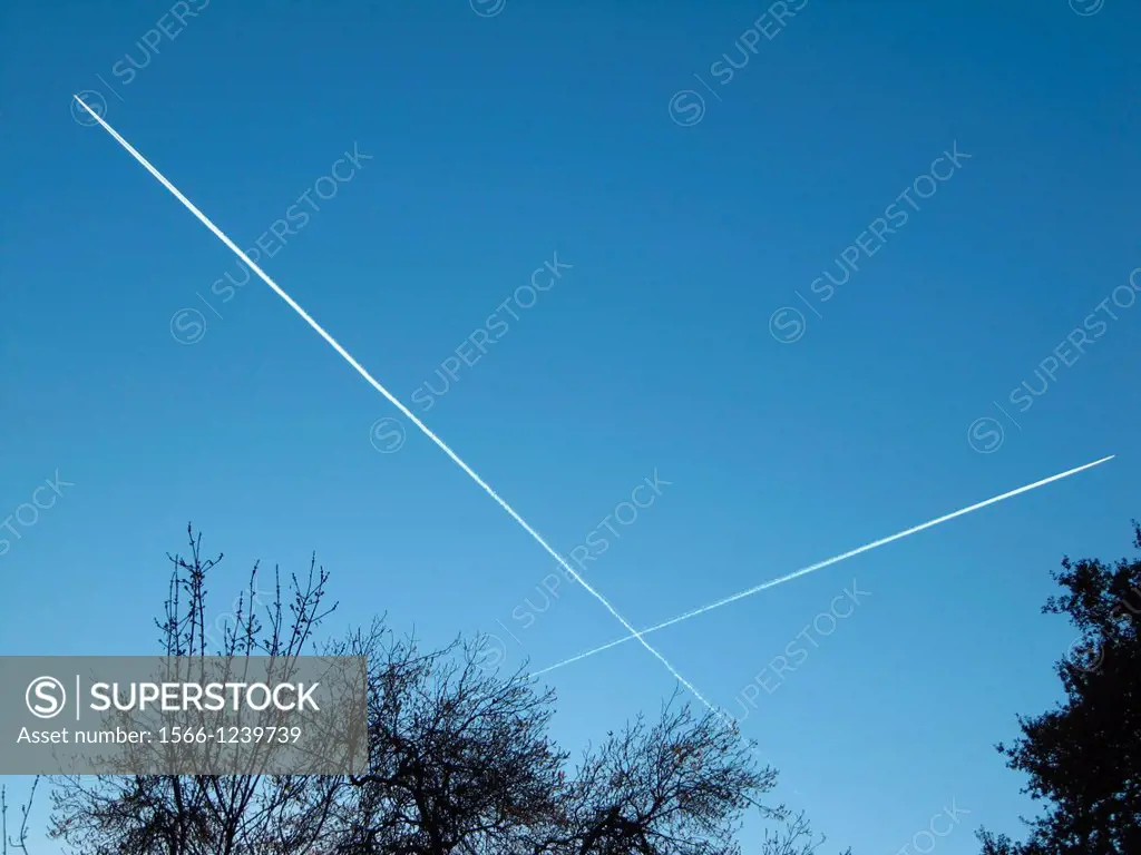 Airplane contrails against blue sky, Madrid, Spain.