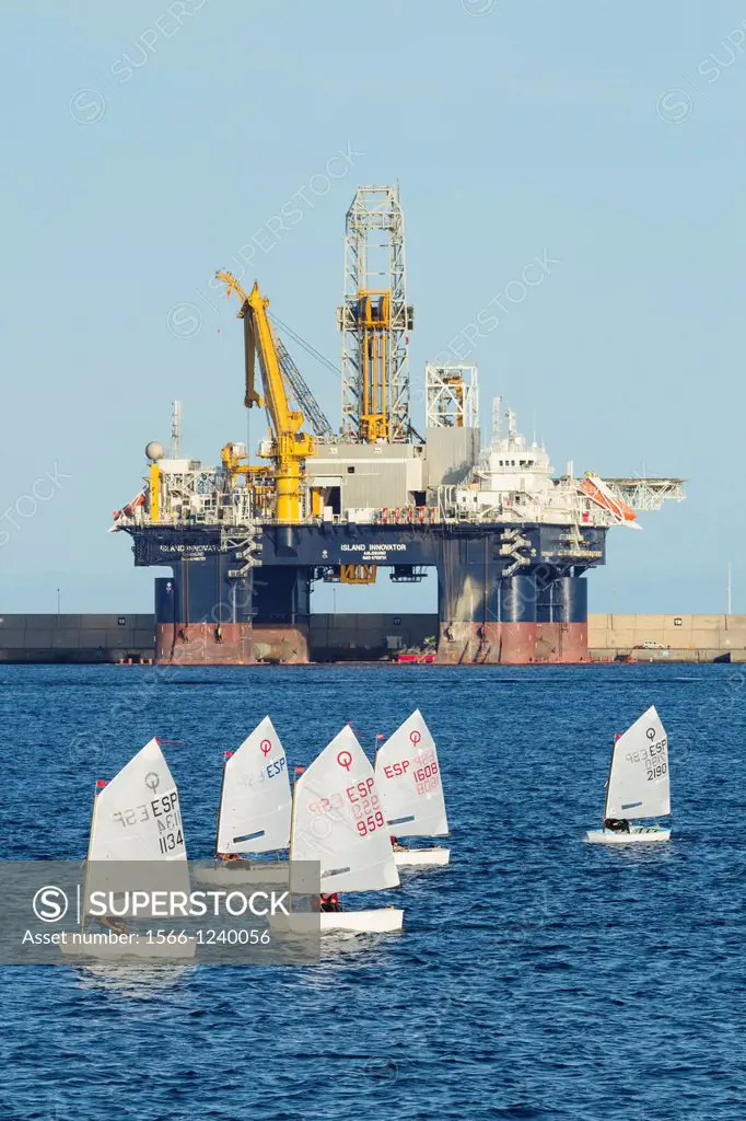 Optimist dinghies sailing in front of ´Island Innovator´ semi submersible drilling rig in Las Palmas port on Gran Canaria