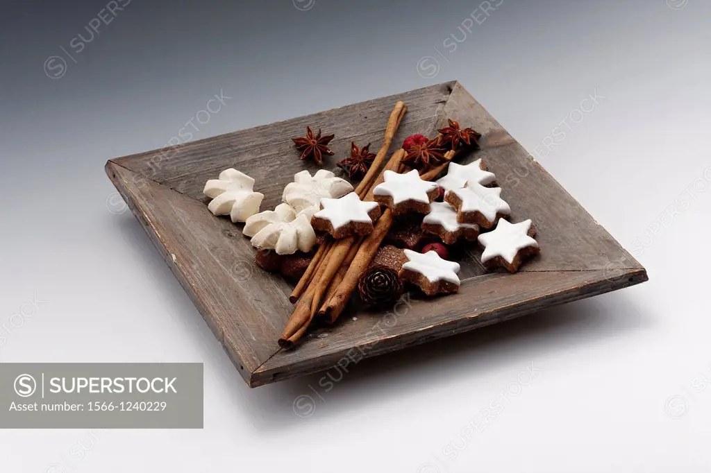 fruits of star anise - Illicium verum - cinnamon sticks in wooden bowl - Cinnamomum cassia - cinnamon star and anise flavoured cookies at christmas