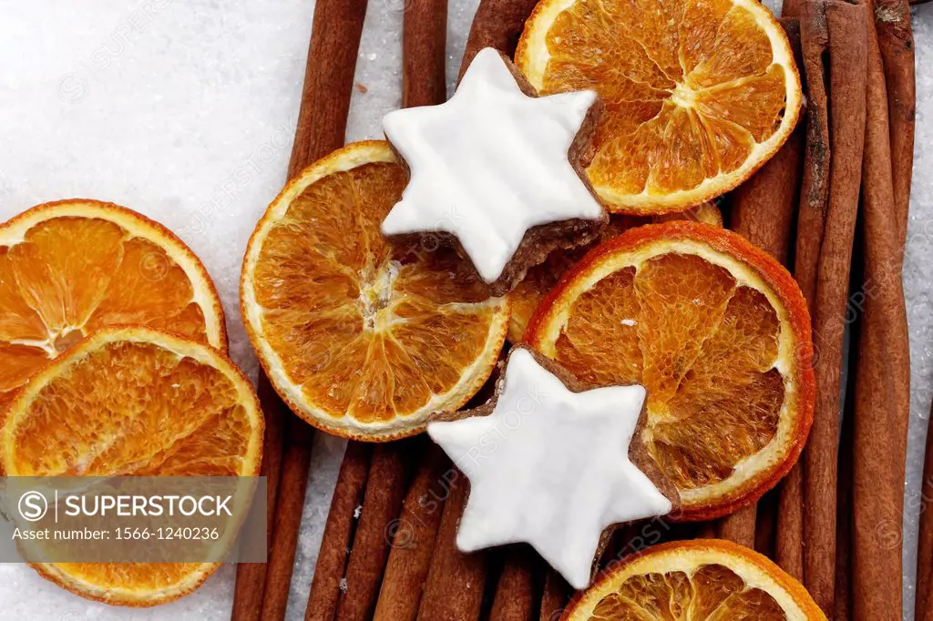 cinnamon sticks - Cinnamomum cassia - dried orange slices - cinnamon star cookies at christmas - artificial snowflakes