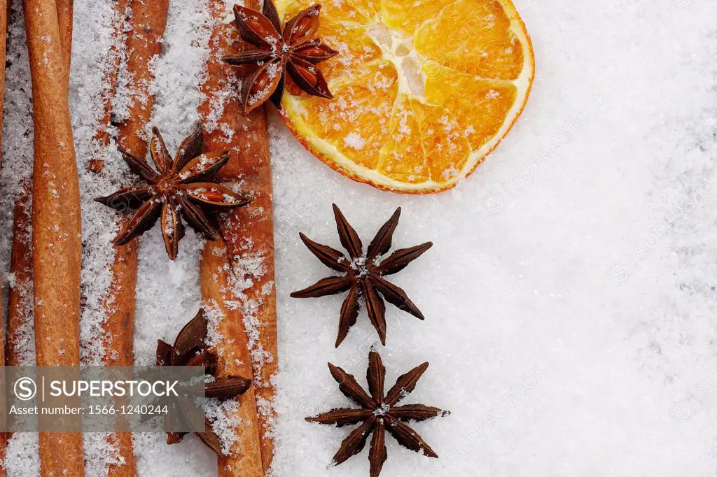 fruits of star anise - Illicium verum - cinnamon sticks - Cinnamomum cassia - dried orange slices - potpourri on artificial snowflakes