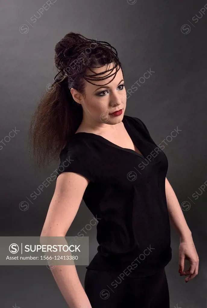 Model in black impersonating mannequin with hair style.
