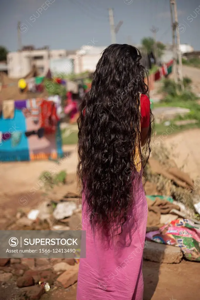 A beautiful woman drying her hair in a slum in India