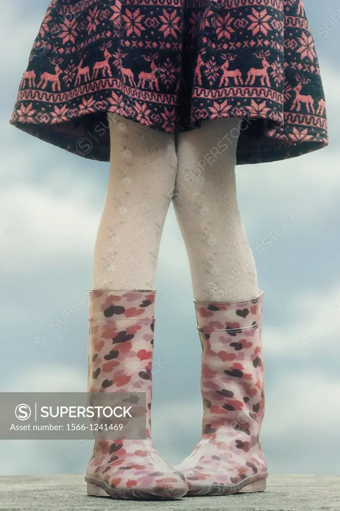 a girl in wellies on a table