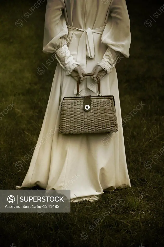 a woman in a victorian dress with a handbag made of bast
