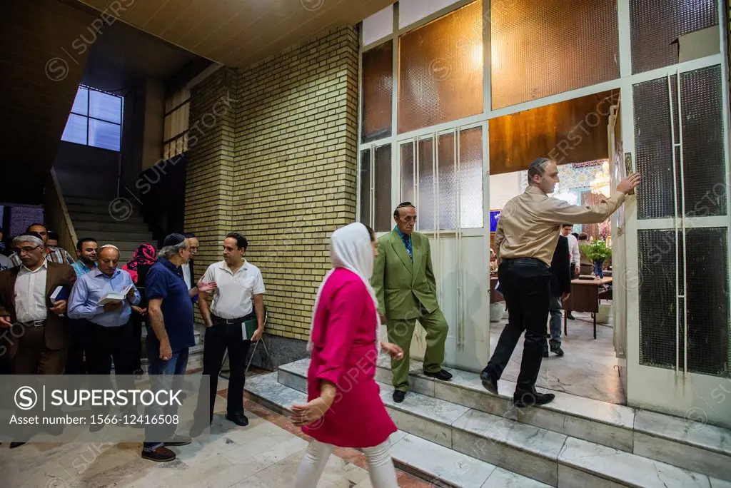 Jews come in praying hall of Yusef Abad Synagogue, one of the biggest in Northern Tehran, and touching mezuzah, ritual piece of parchment, on Rosh Has...