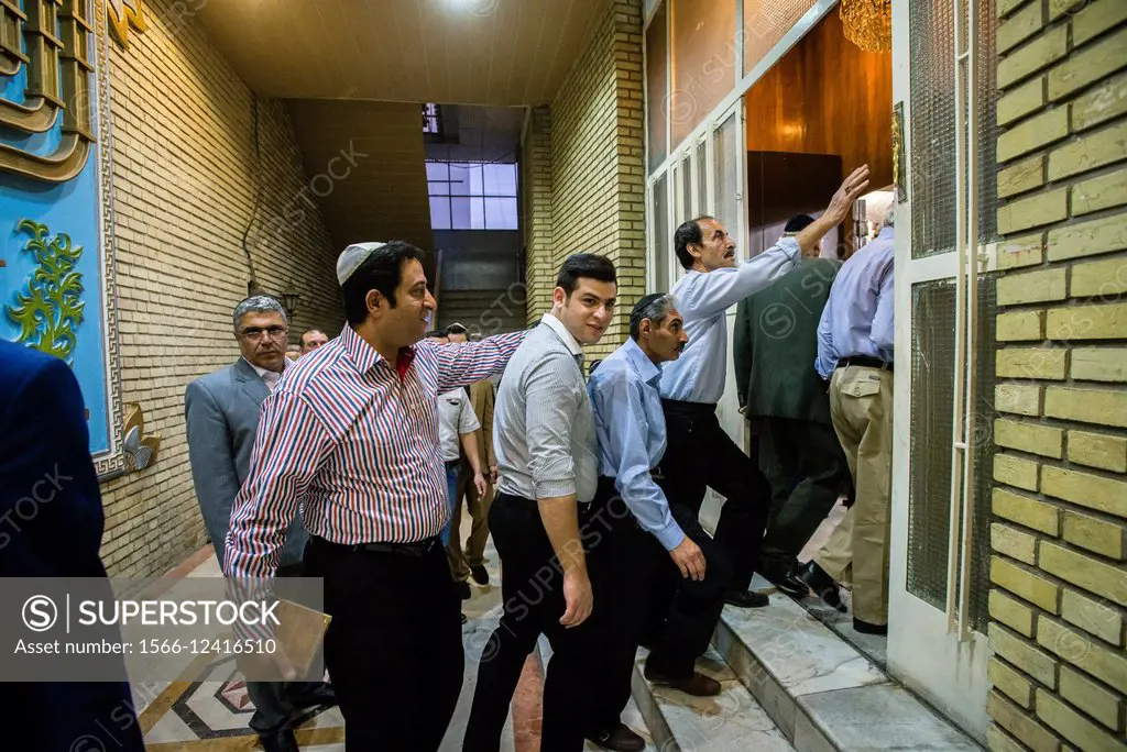 Jews come in praying hall of Yusef Abad Synagogue, one of the biggest in Northern Tehran, and touching mezuzah, ritual piece of parchment, on Rosh Has...
