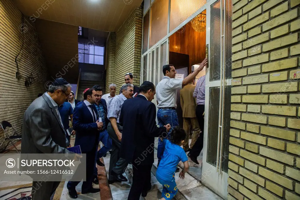 Jews come in praying hall of Yusef Abad Synagogue, one of the biggest in Northern Tehran, and touching mezuzah, ritual piece of parchment, on Rosh Has...