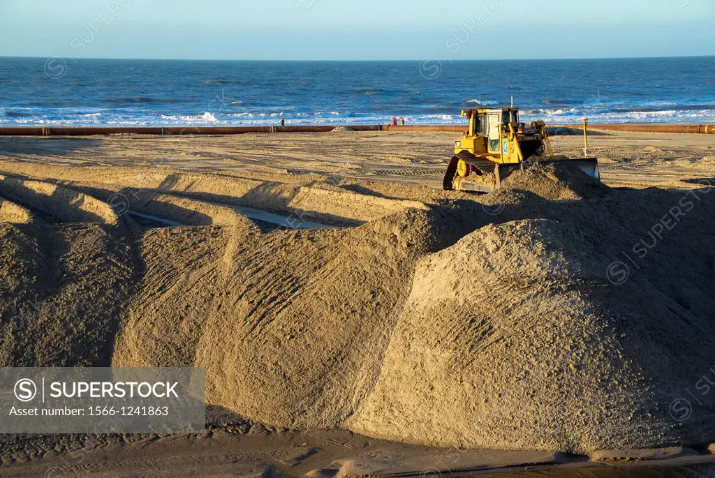 bulldozer at work at sand supply at the beach in the Netherlands