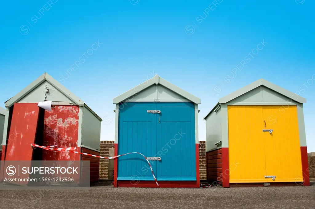 Three Beach huts in a Row With One Very Run Down Hut on Brighton Seafront, Sussex, England