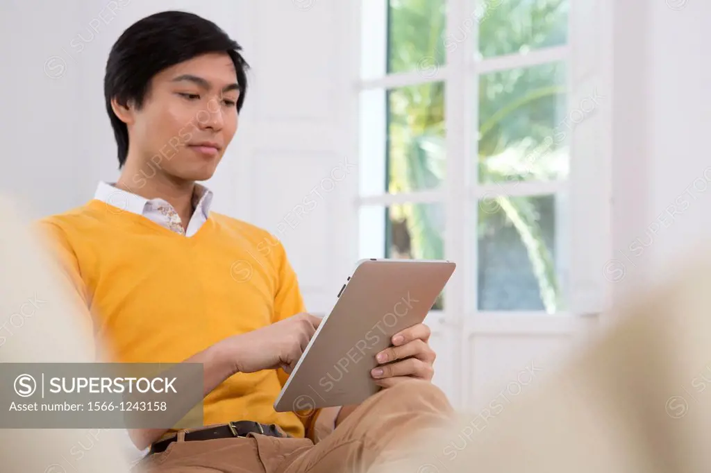 Young Asian man using his Tablet computer