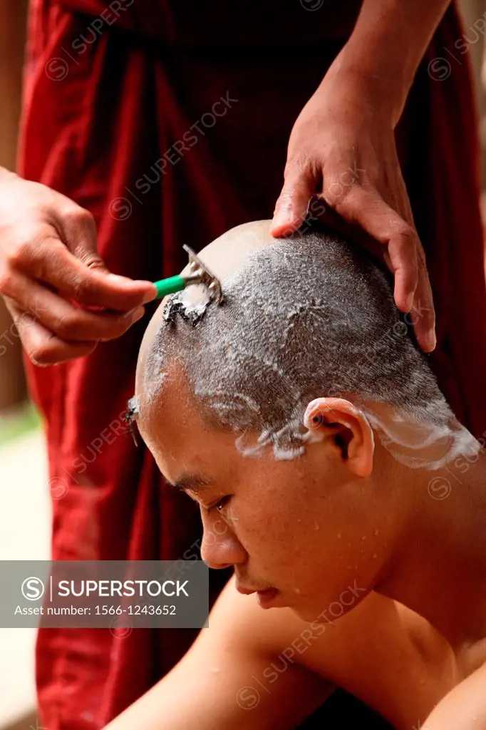 Monk shaving head of novice prior to entering the monastery, Myanmar, Burma, Asia