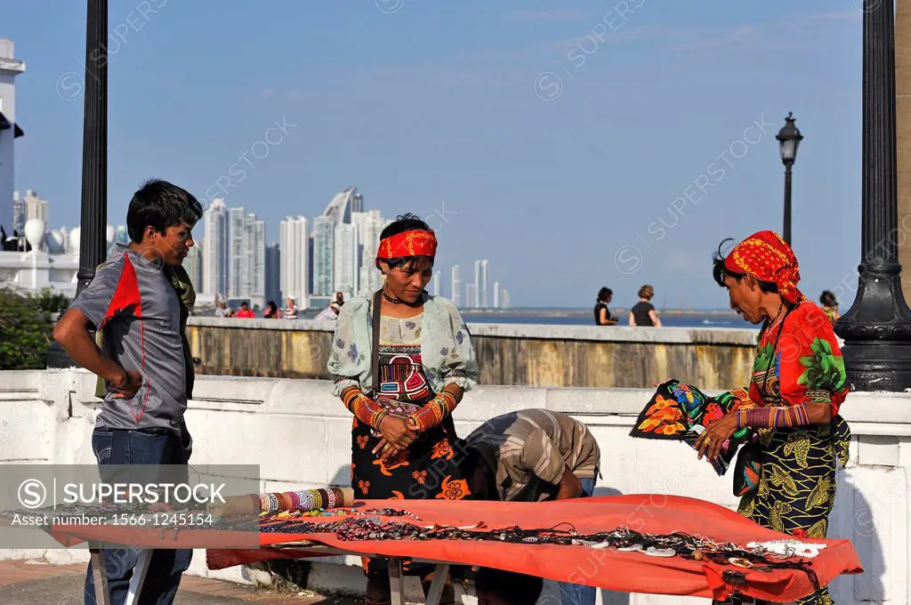 Kuna women selling gifts at the promenade built atop the old city´s outer wall, Casco Antiguo the historic district of Panama City with the skyline of...