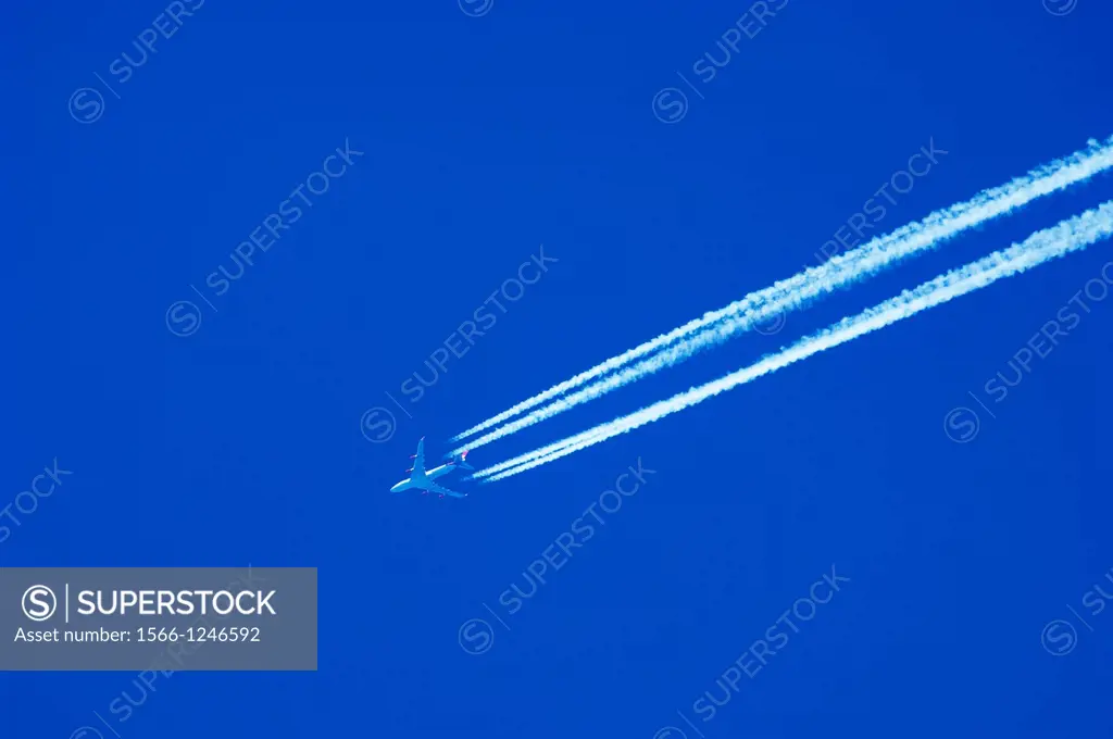 A passenger jet liner flying at high altitude leaving vapour trails against a clear blue sky