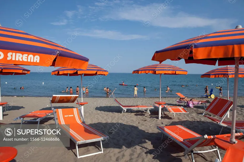Brightly colored umbrellas and beach chairs at a popular beach in Policoro, Basilicata, Italy