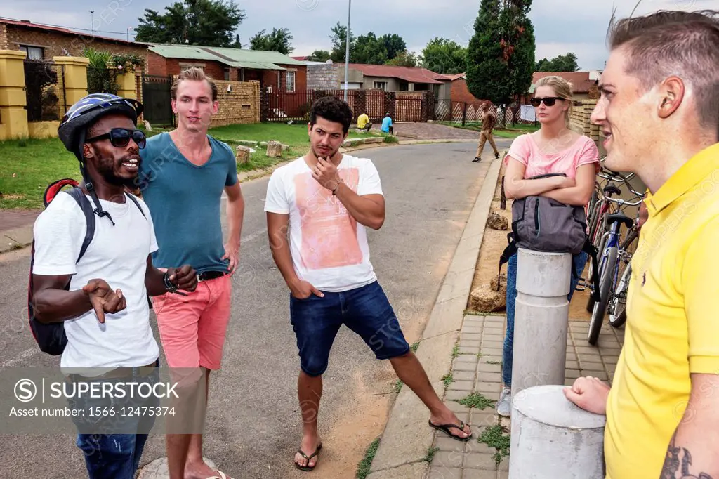 South Africa, African, Johannesburg, Soweto, Vilakazi Street Precinct, Black, man, guide, talking, explaining, woman, listening.