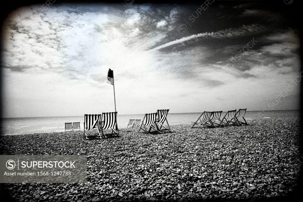 Brighton, Sussex, England, UK, lonely pebble beach with striped deckchairs,