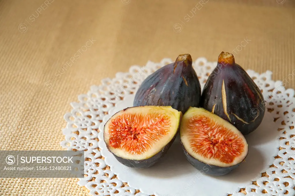 Three black figs, one of them cut in two halves.