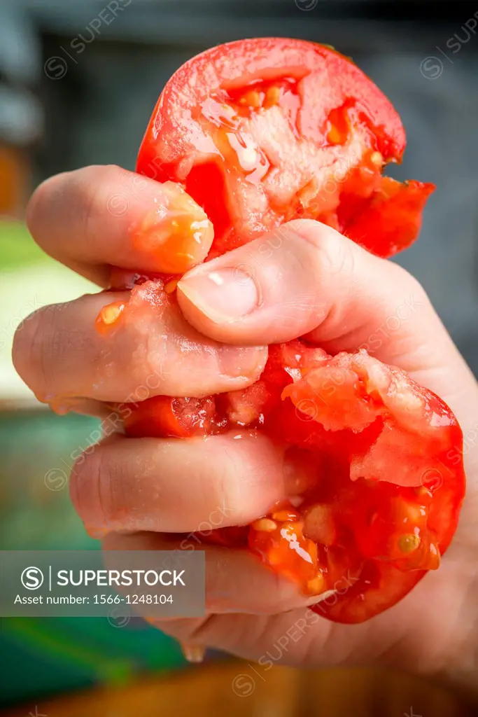 Tomato crushed in fingers
