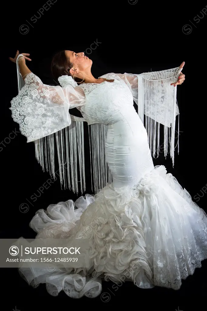 Flamenco dancer dressed in white with expression of feeling passionate in black background.