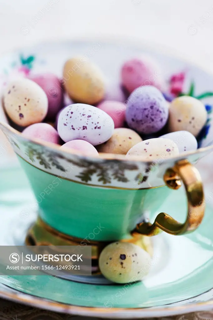 Candy coated chocolate easter eggs in antique china tea cup.